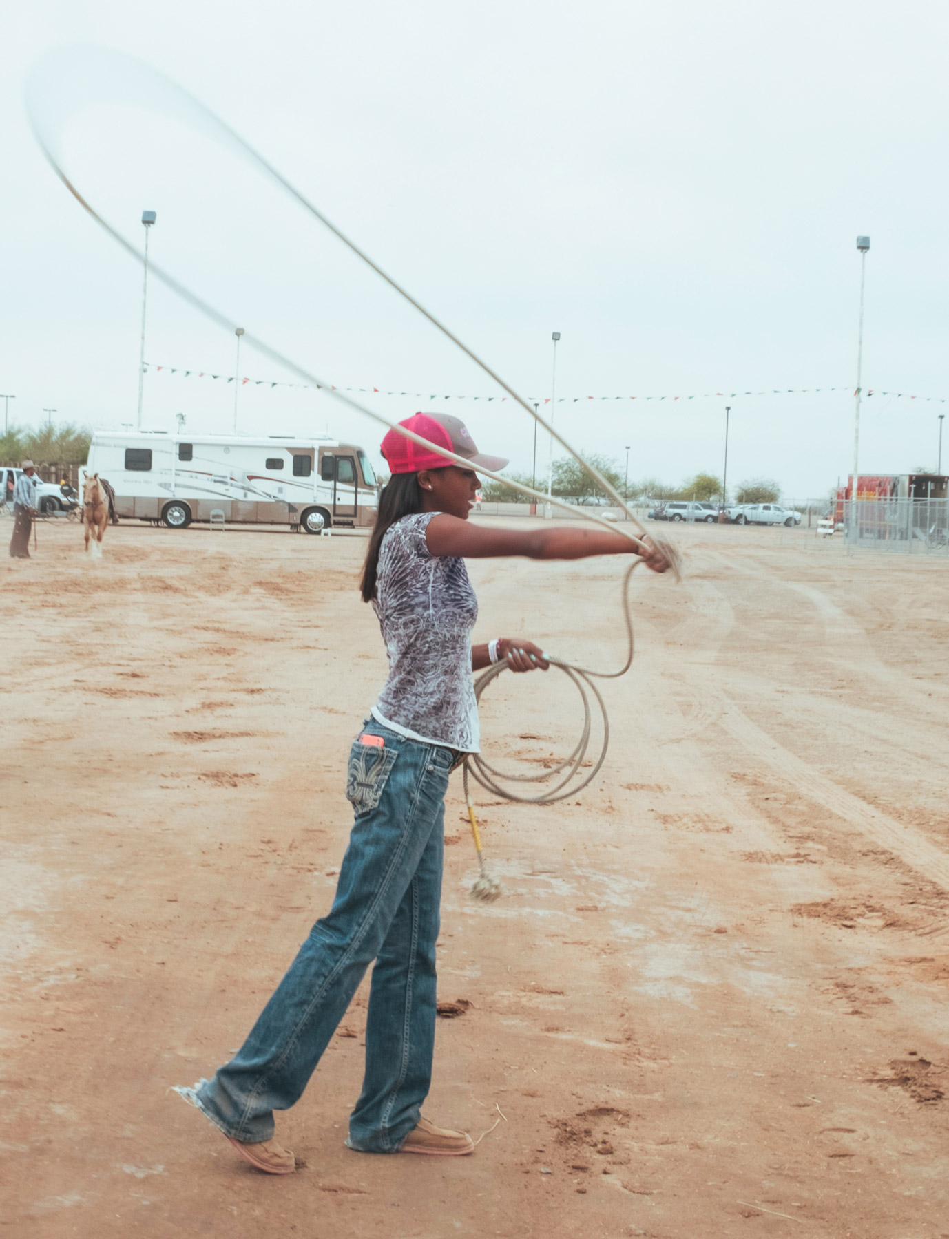 Young woman outside throwing a lasso