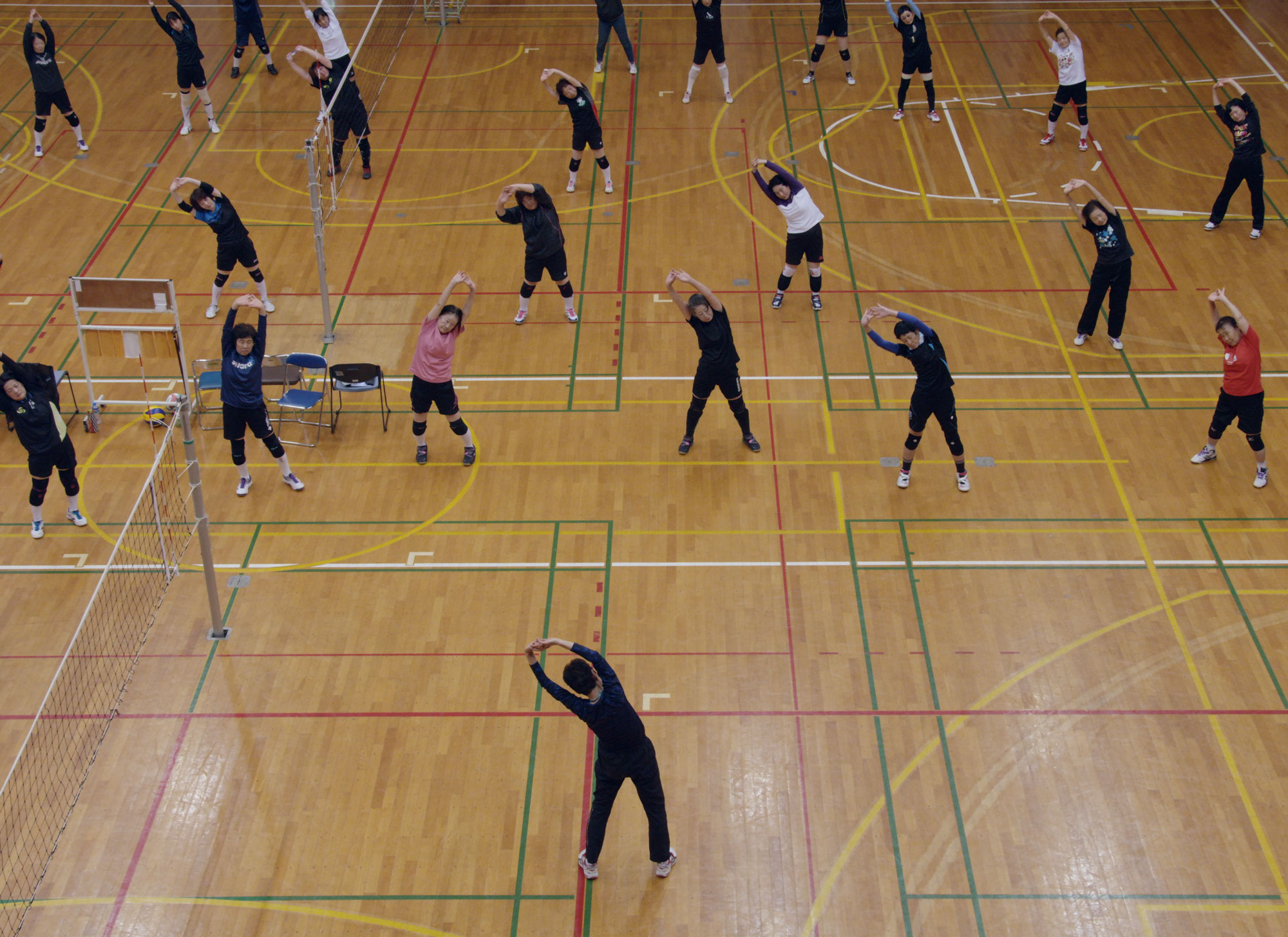 Women in sports hall stretching