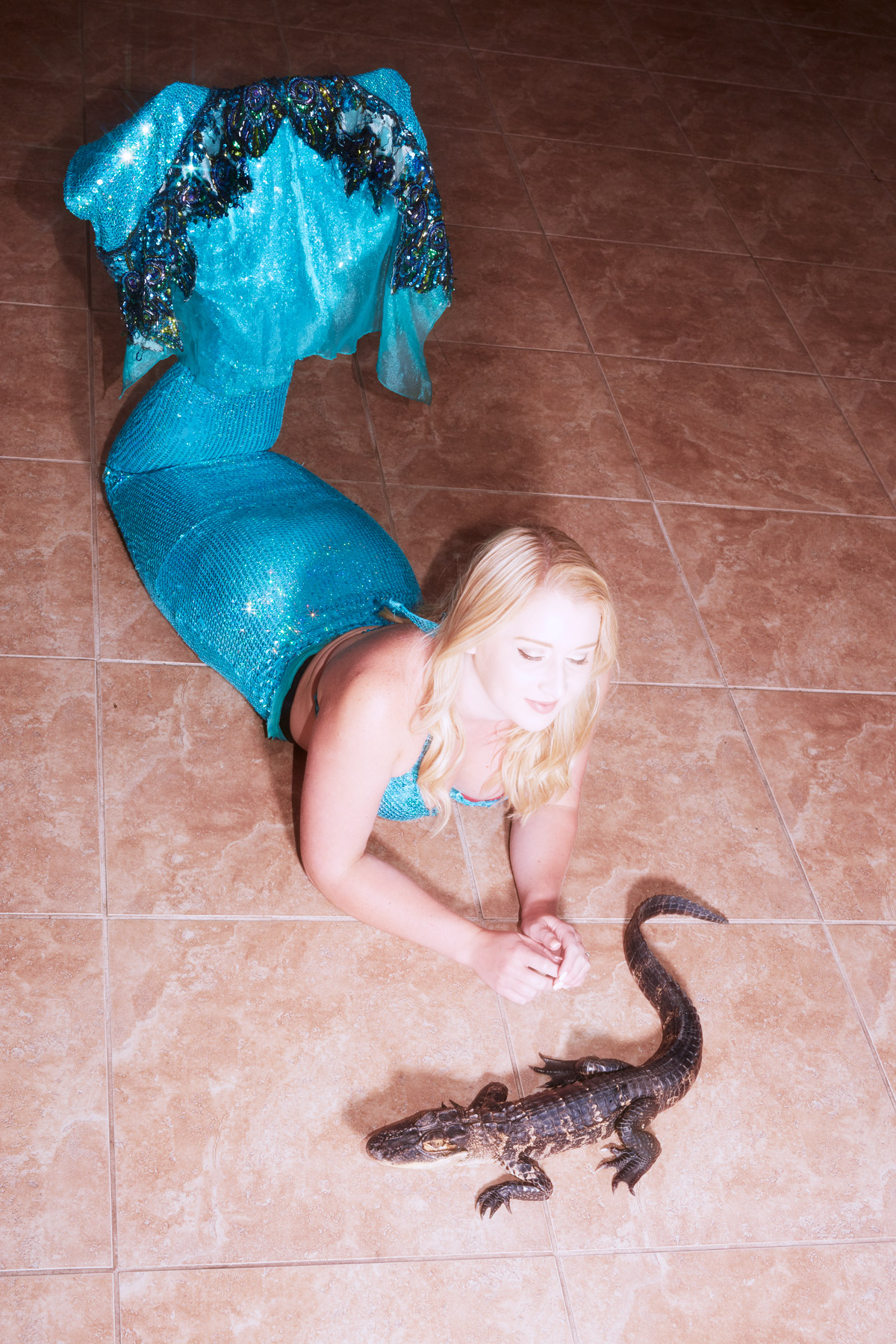 glorious mermaids charlie engman florida mermaid laying on floor playing with small alligator