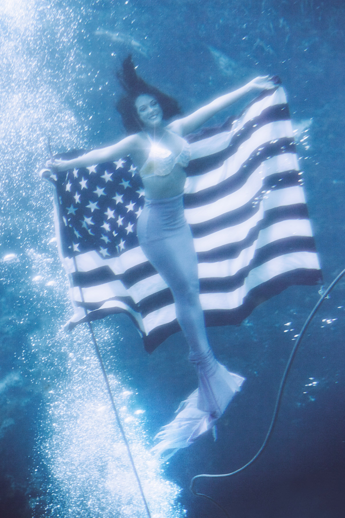glorious mermaids charlie engman florida mermaid smiling posing underwater performance holding usa flag